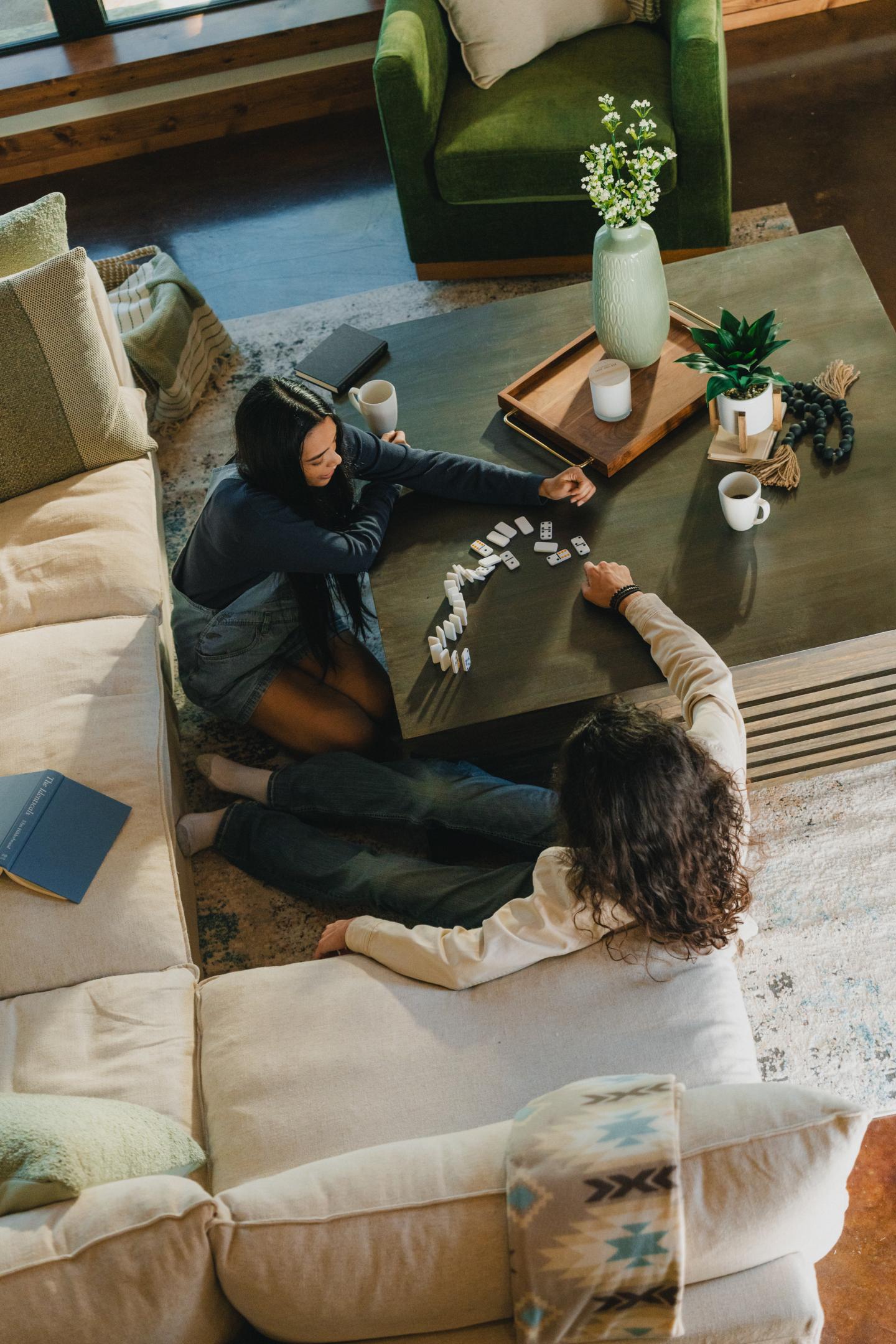 Two people playing a game on a coffee table in a cozy living room.